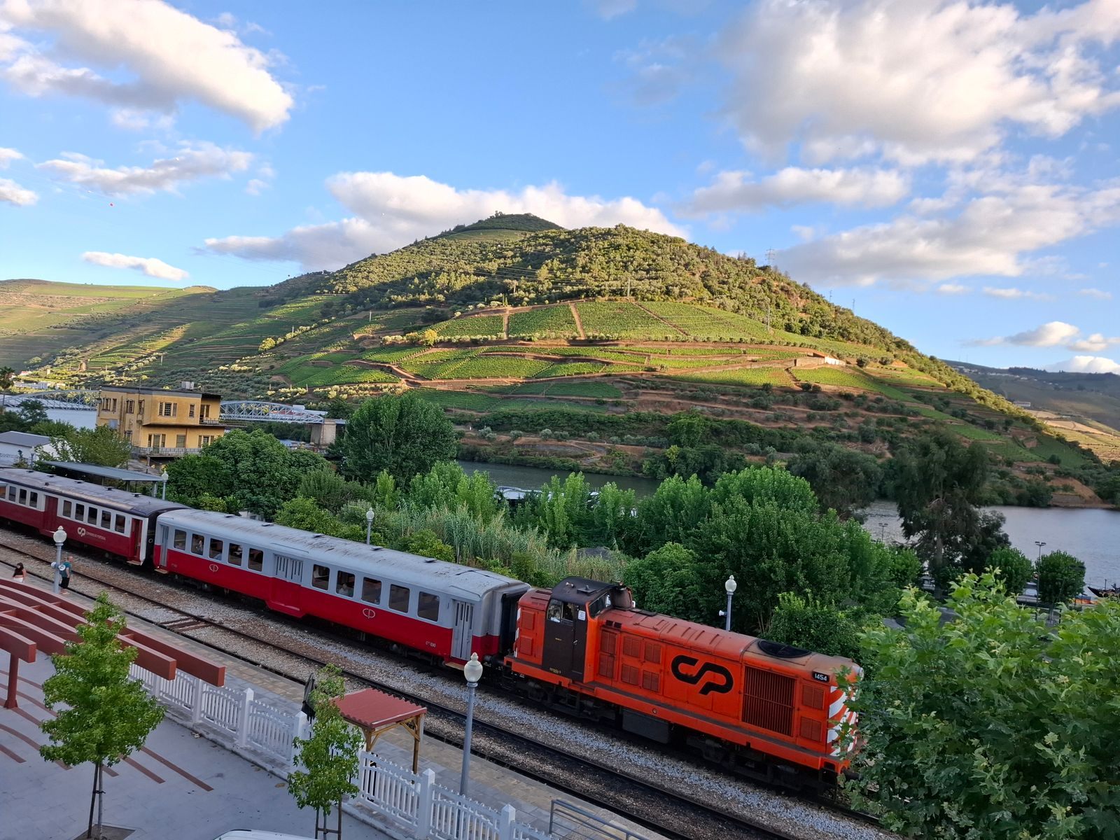 Train at a station in the Douro Valley below vineyard hills, a popular excursion priced into some Douro Valley river cruise cost