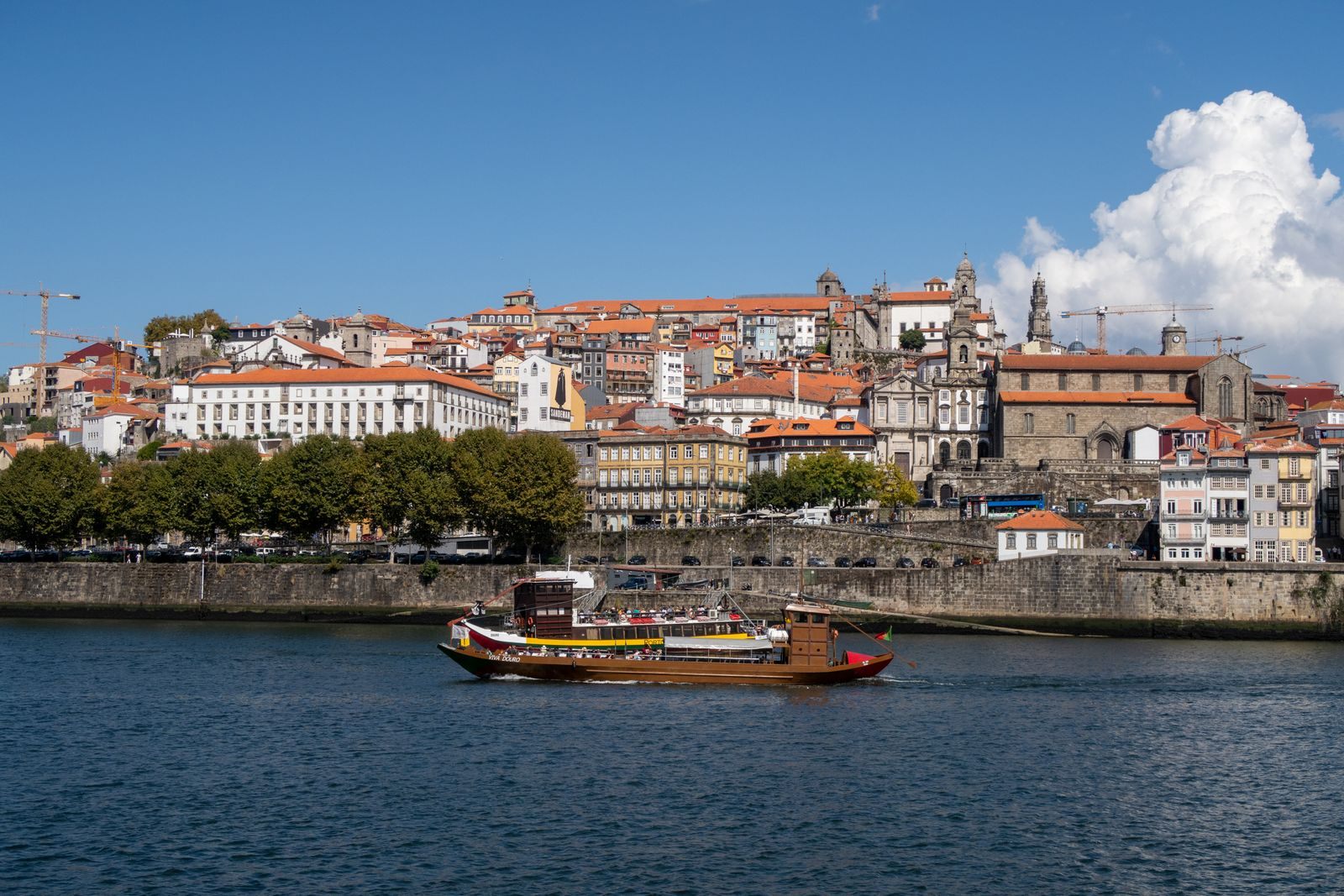 Traditional rabelo boat on the Douro in front of Porto’s colorful riverside houses
